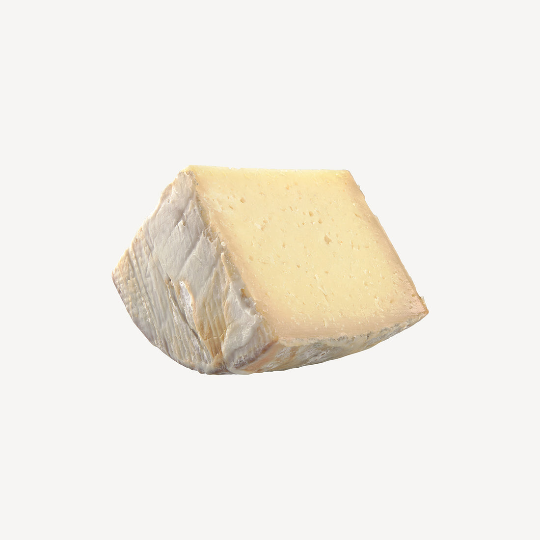 La cuña de queso artesano manchego envejecido en manteca, un preludio visual a un sabor rico y textura suave, marcados por la tradición.