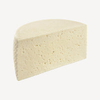 Un corte del queso tierno revela su interior cremoso, un testimonio visual de la suavidad y la calidad artesanal.