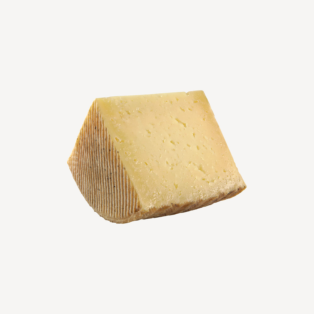 La cuña de queso curado manchego destaca la perfección de la maduración, un preludio a un viaje de sabor intenso y textura exquisita.