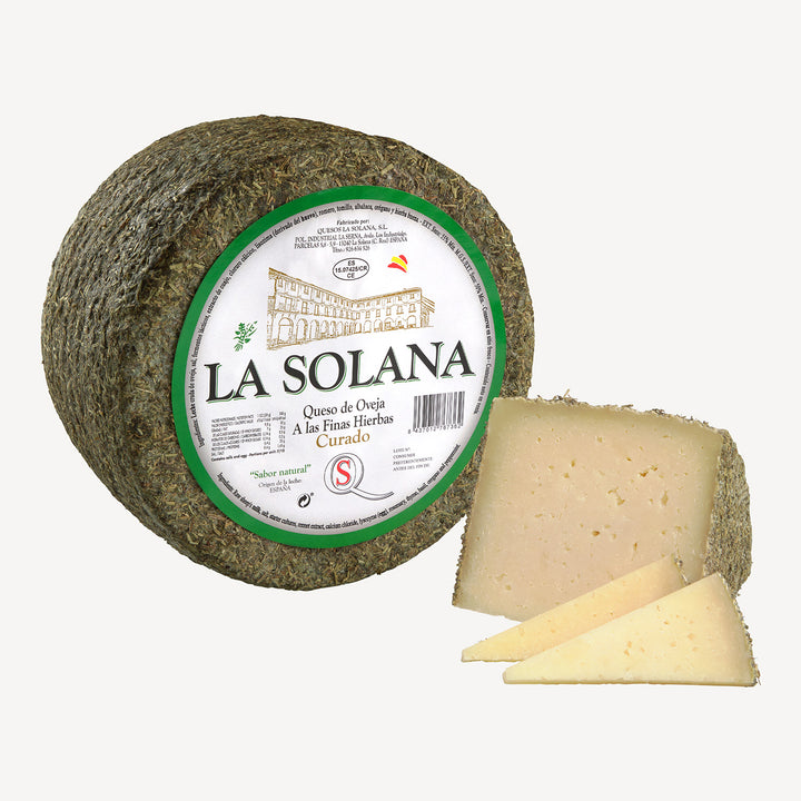 Vista elegante del queso entero acompañado de porciones cortadas, destacando la armonía entre la textura firme y los aromas herbales.