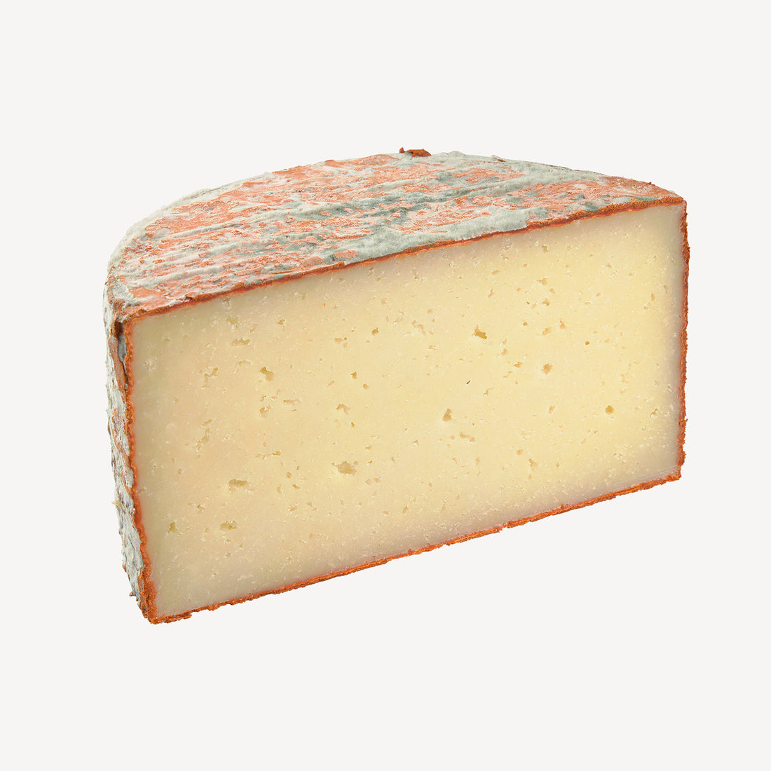 La vista lateral del queso muestra la penetración del pimentón, una invitación visual a explorar un sabor que combina tradición y picante.